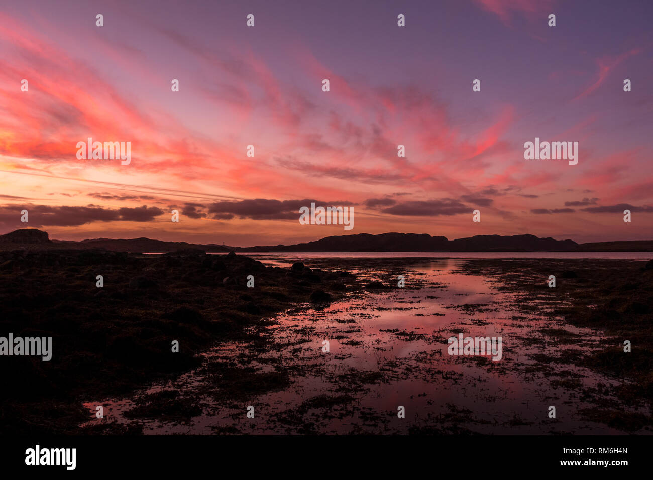 Splendide costiere tramonto rosa da Ardtun vicino guardando verso Bunessan attraverso il mare, isola di Sky Foto Stock