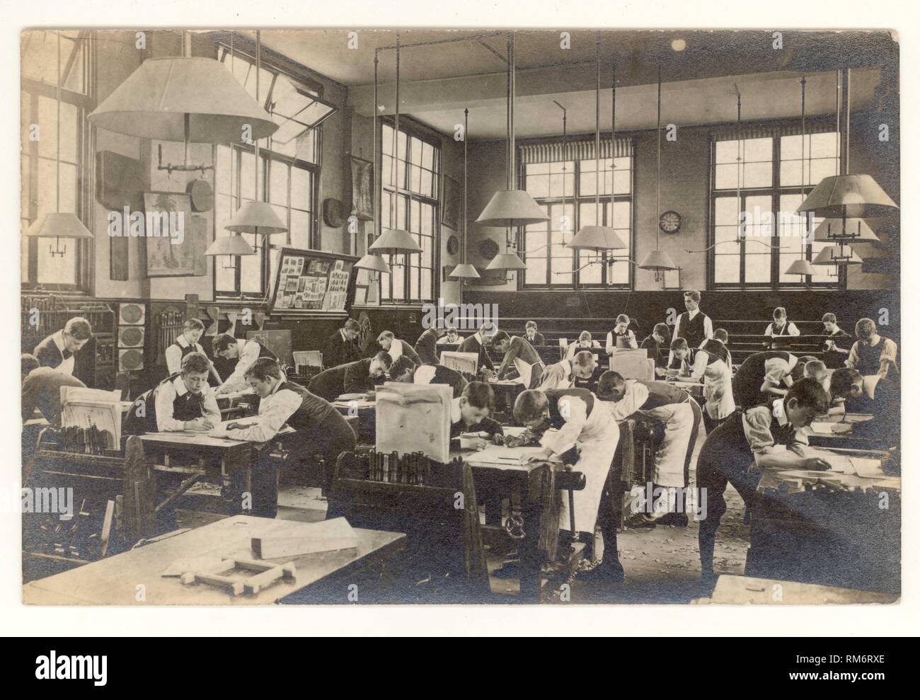 Cartolina edoardiana originale dei primi anni '1900 degli scolari edoardiani che disegnano piani per la lavorazione del legno, falegnameria in una vecchia classe, intorno al 1910, Regno Unito Foto Stock