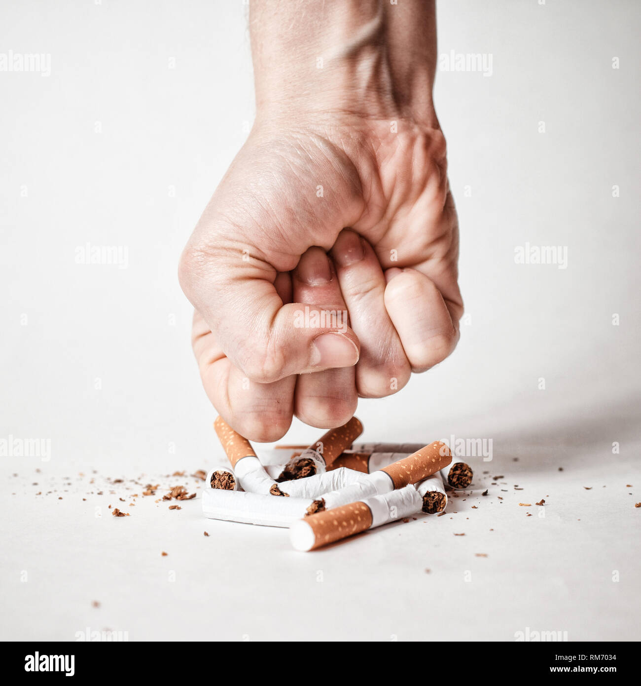 Mano d'uomo la frantumazione di sigarette. Ora smettere di fumare Foto Stock