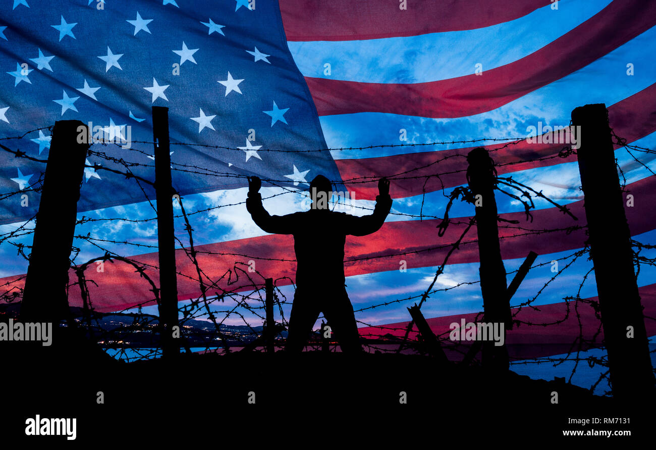 Uomo che guarda attraverso il filo spinato/filo di rasoio recinto con Stati Uniti a stelle e strisce bandiera in background. Immigrazione, la recinzione di confine, confine messicano... concetto Foto Stock