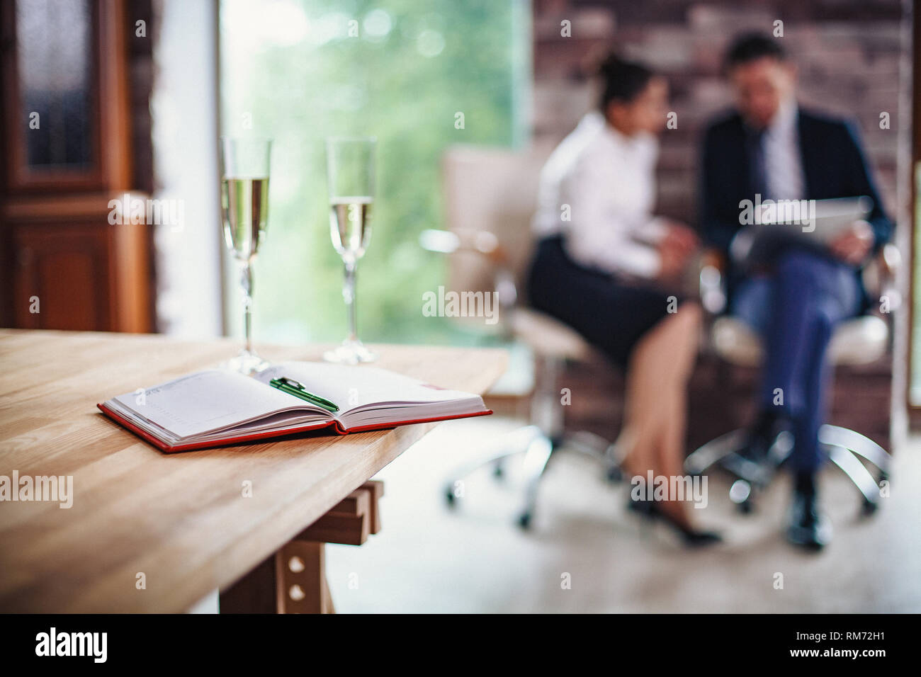 Aprire il notebook e due bicchieri di champagne sul tavolo. Il concetto di business Foto Stock