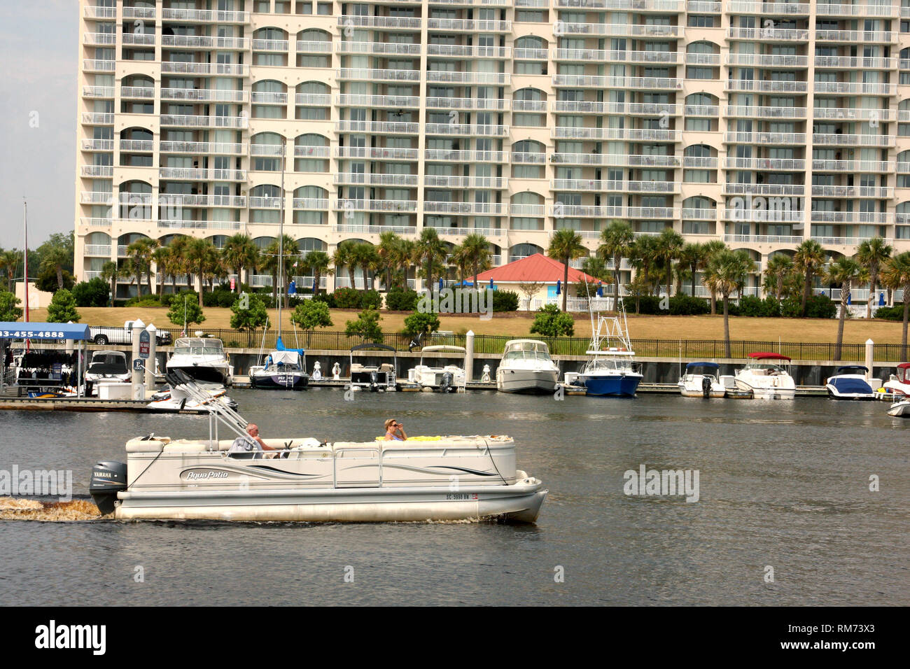 Persone in barca sulla Intracoastal Waterway a Myrtle Beach, SC, USA. North Tower Barefoot Resort sullo sfondo. Foto Stock