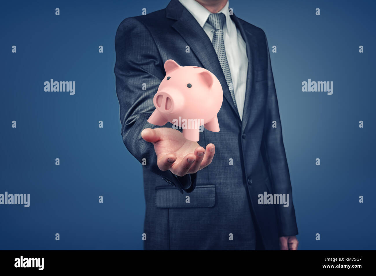 Un imprenditore con faccia nascosta mostra una mano con una rosa salvadanaio in bilico sopra di esso. Foto Stock