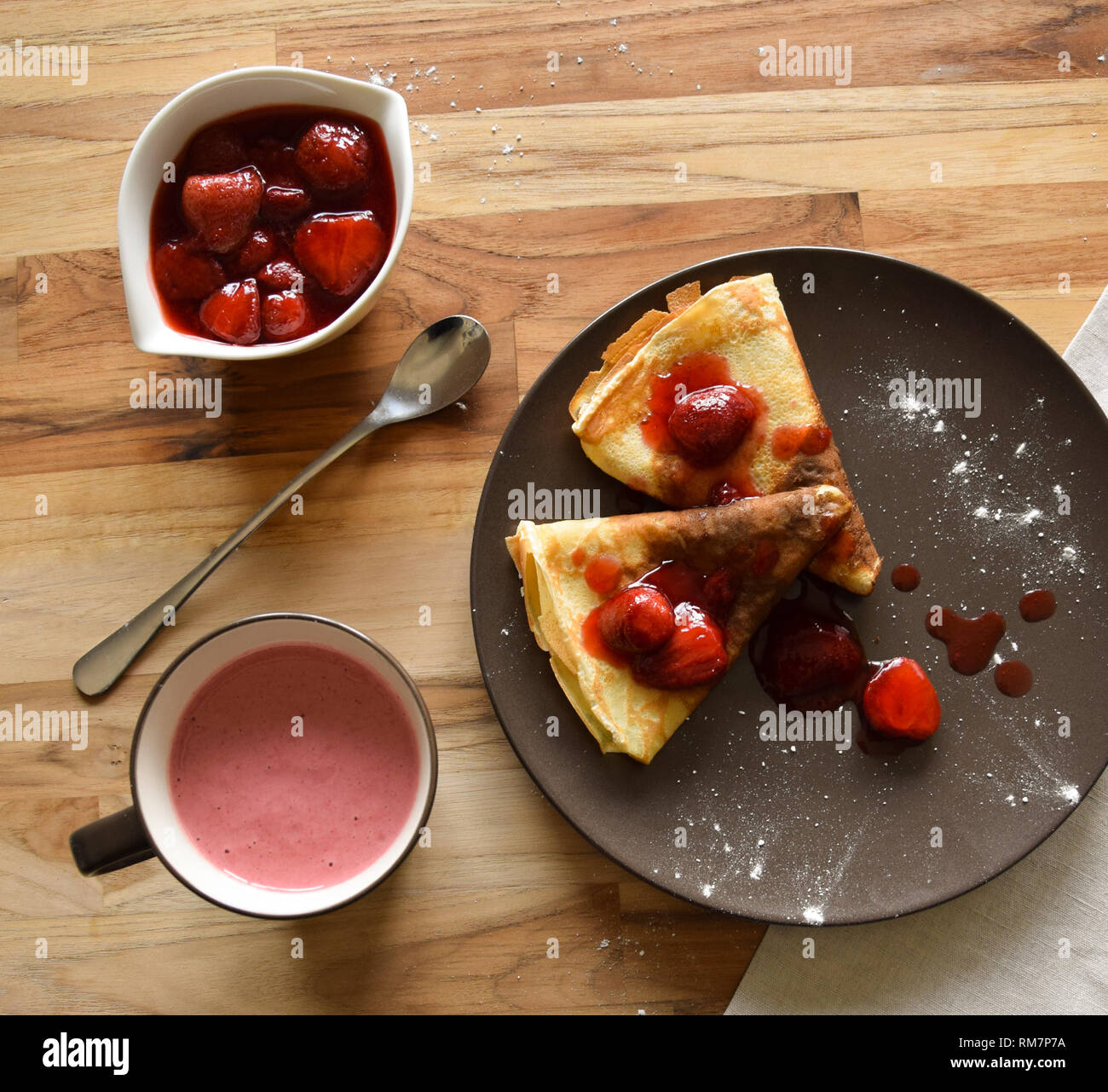 Pancake fatti in casa con ricotta e fragole su una piastra. Sfondo di legno. Foto Stock