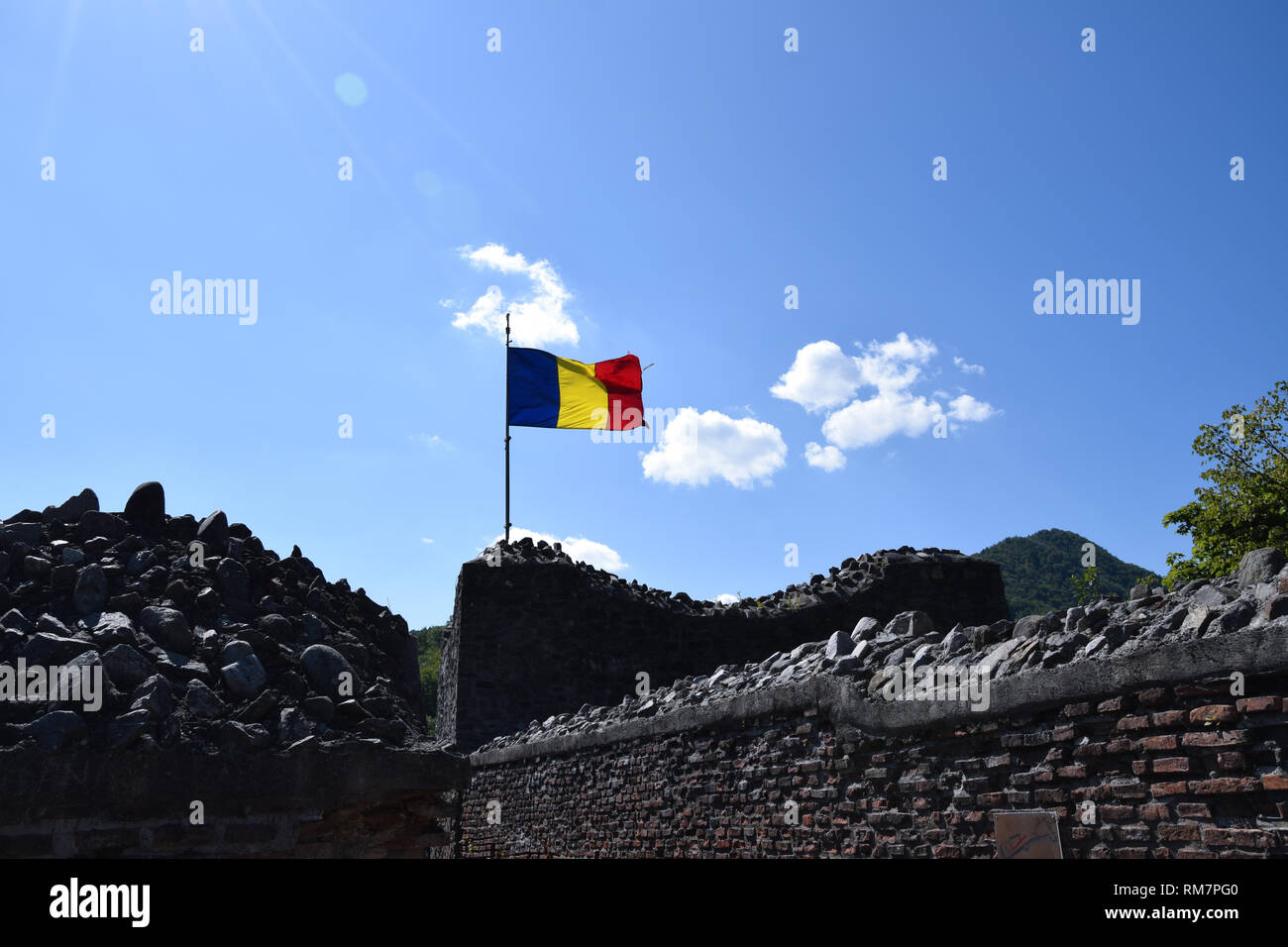 Bandiera rumena sventolare nel vento presso la rovina del castello di Poenari. La Romania bandiera nazionale. Foto Stock