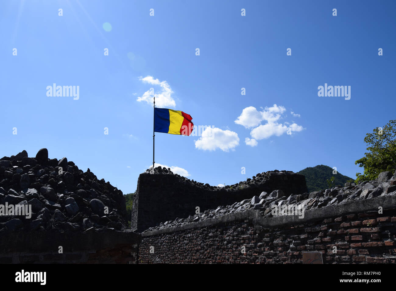 Bandiera rumena sventolare nel vento presso la rovina del castello di Poenari. La Romania bandiera nazionale. Foto Stock