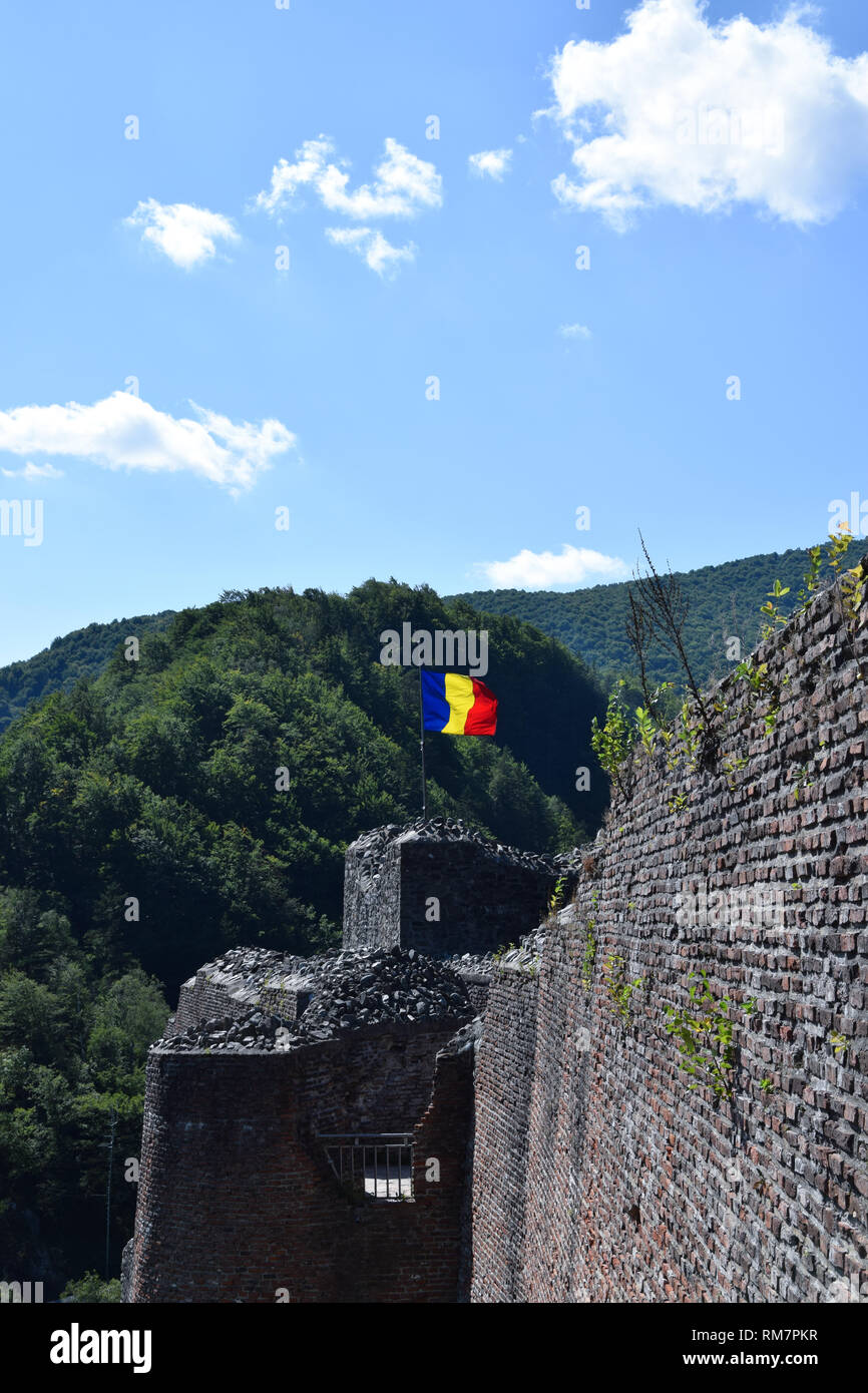 Bandiera rumena sventolare nel vento presso la rovina del castello di Poenari. La Romania bandiera nazionale. Foto Stock