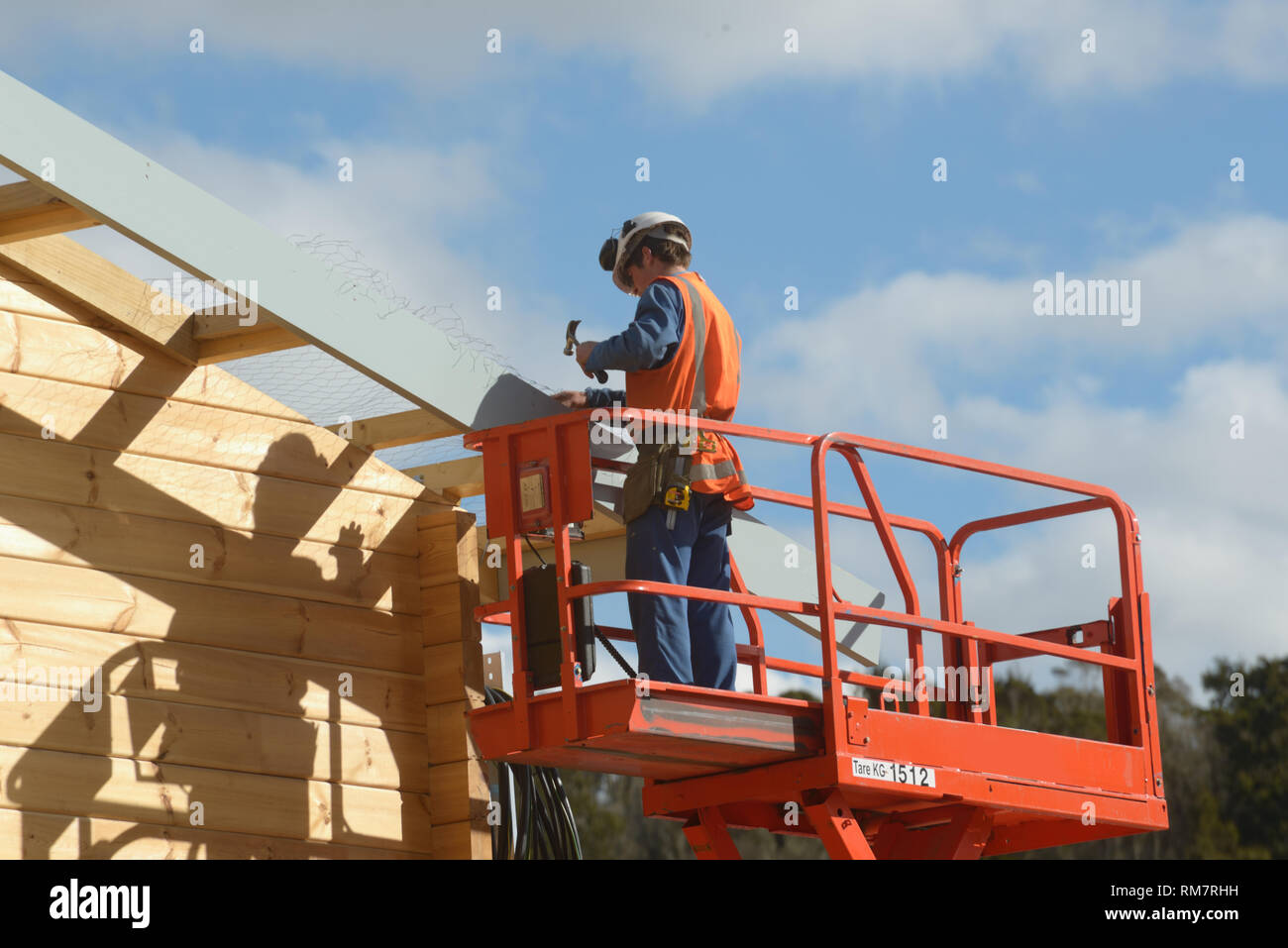 Un builder attribuisce lavoro a rete di filo per un edificio in preparazione per la messa sul tetto Foto Stock