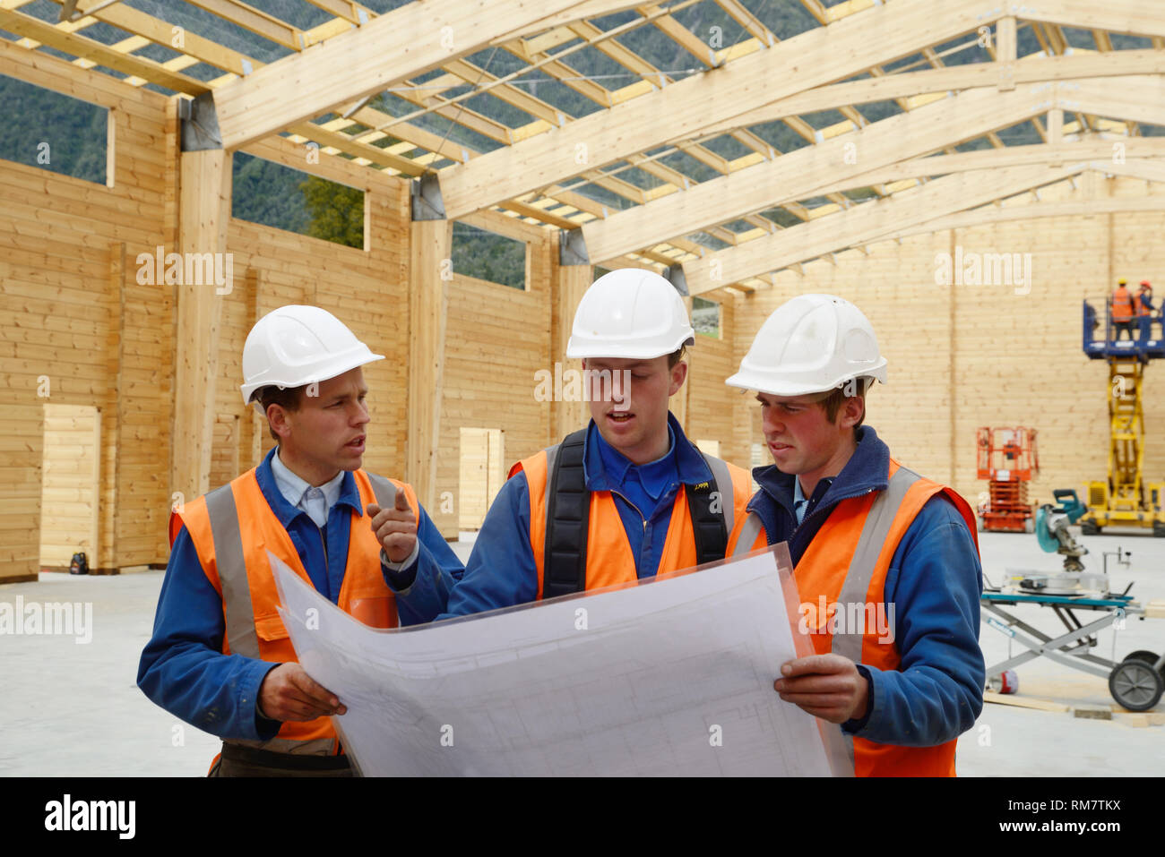 Tre costruttori di discutere il piano per un importante lavoro di costruzione Foto Stock