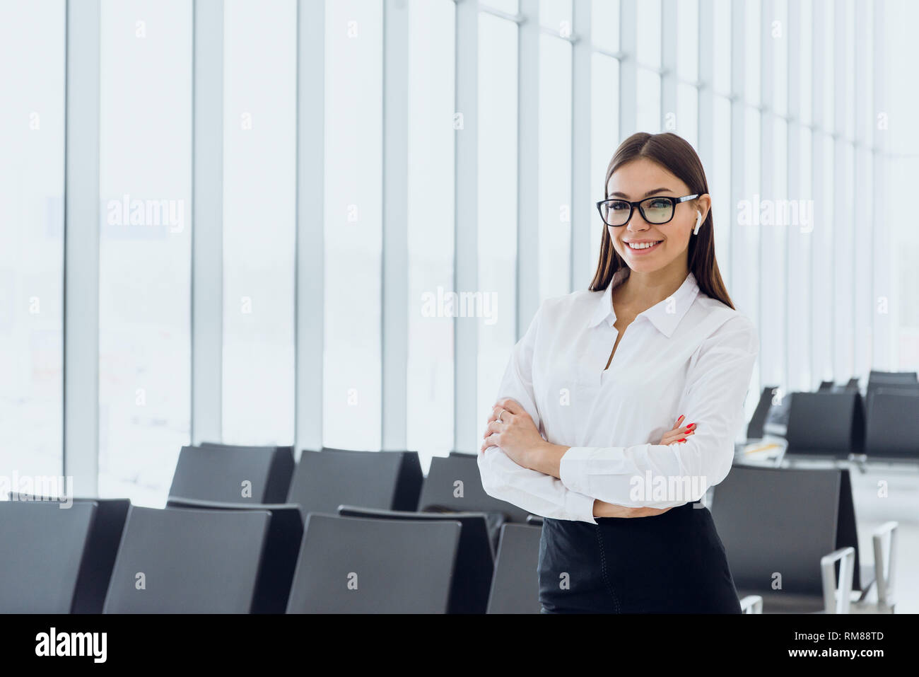 Ritratto di sorridere attraente donna d'affari in aeroporto hall. Spazio di copia Foto Stock