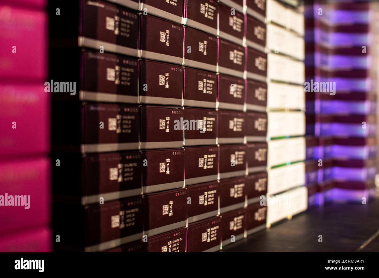 Al di sopra di vista delle persone che lavorano in grandi magazzini, contando le merci sul carrello in movimento tra gli scaffali con scatole confezionate Foto Stock