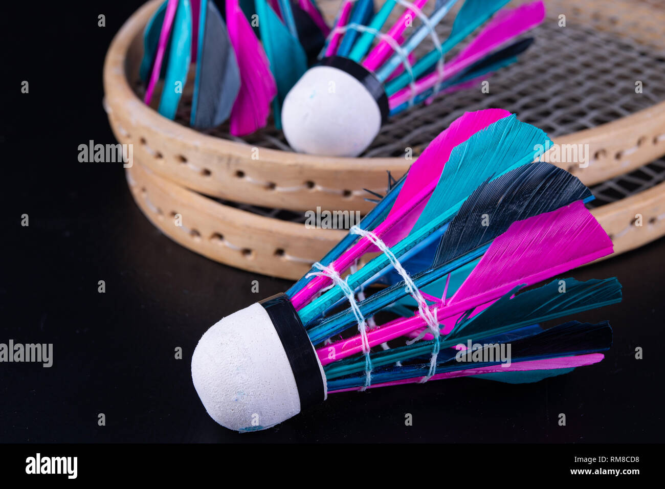 Piume colorate in badminton volano. Il gioco di squadra impostato. Sfondo  scuro Foto stock - Alamy