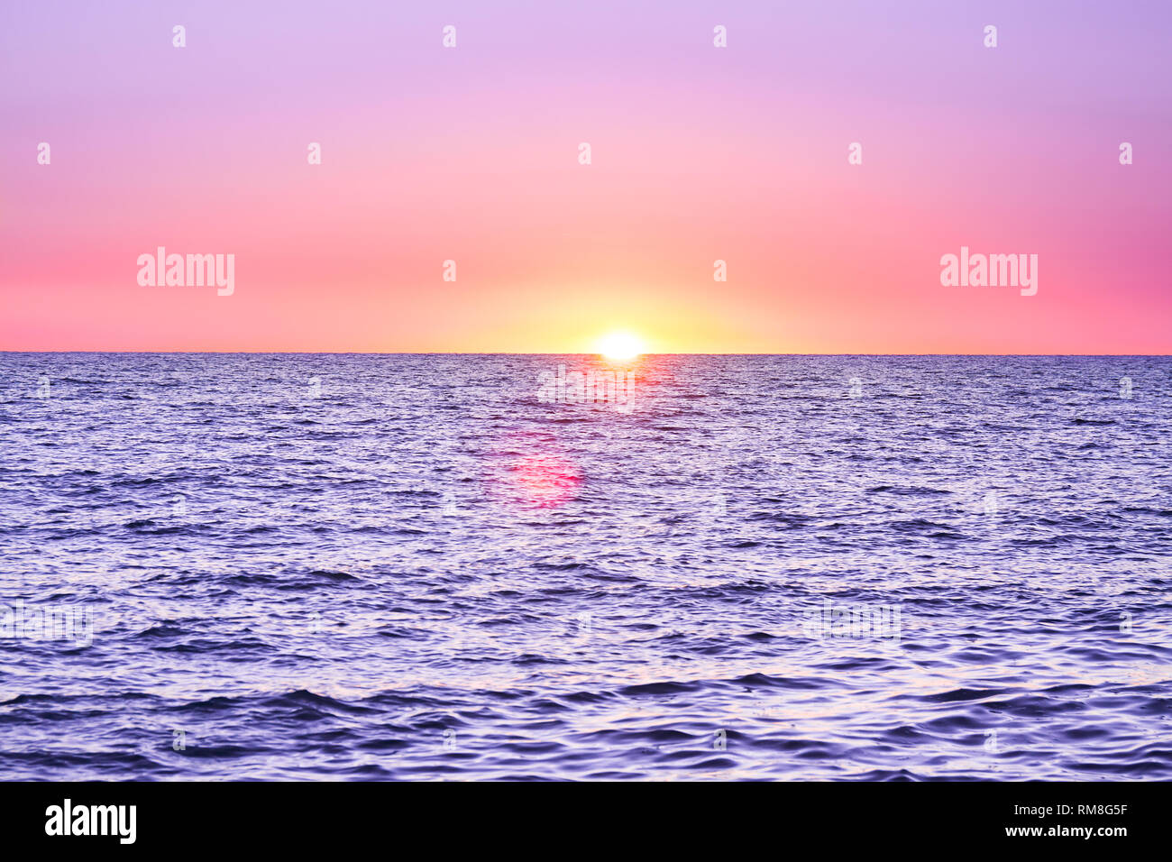 Viola paesaggio con mare e tramonto. sera sun oltre oceano. Uno splendido scenario con il tramonto sul mare vista panoramica Foto Stock