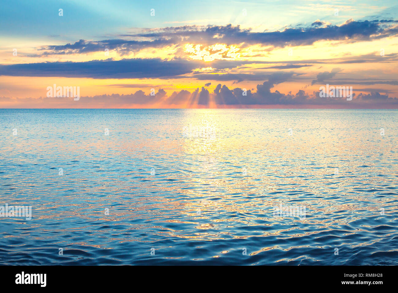 Paesaggio marino con un tramonto Cielo di sera con le nuvole e sole oltre oceano. raggi di sole risplendere rompere attraverso le nuvole Foto Stock