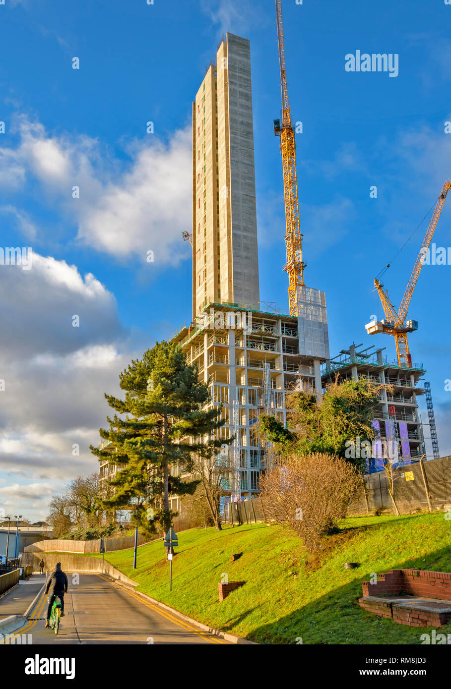 LONDON North Acton ciclista e la costruzione di nuovi appartamenti o blocco di appartamenti vicino alla stazione della metropolitana Foto Stock