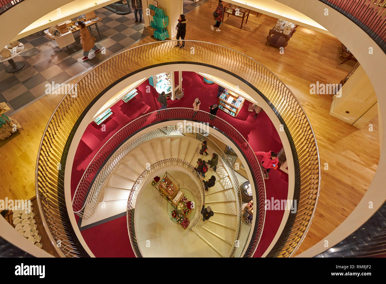 Londra PICCADILLY FORTNUM E MASON interni la scalinata a spirale per tutti i piani e le persone sulle scale Foto Stock