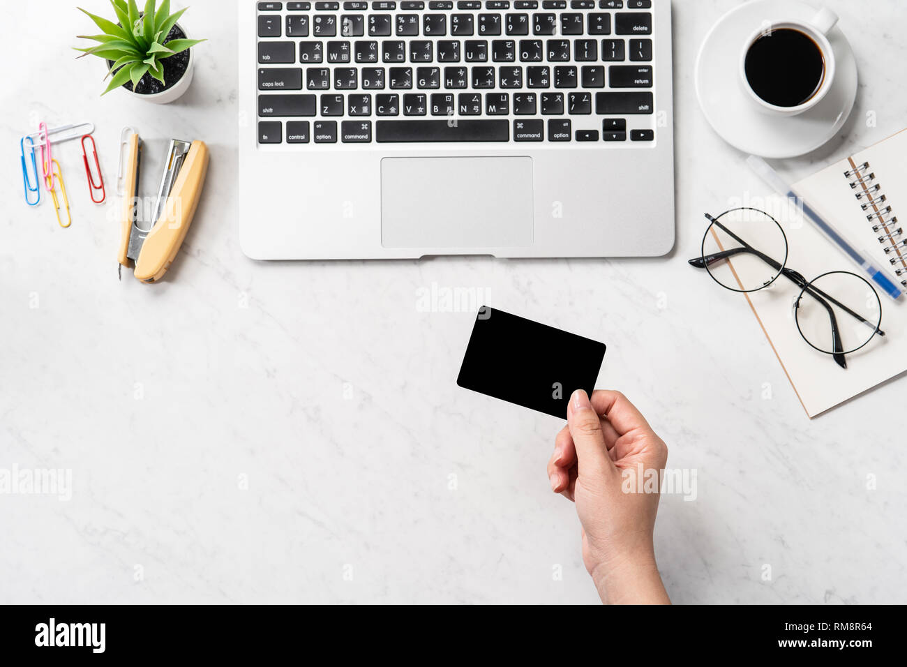 Una donna sta facendo un acquisto online, mock up e della carta di credito cellulare mobile sulla scrivania in ufficio isolato in modo bello sfondo marmo, copia spac Foto Stock
