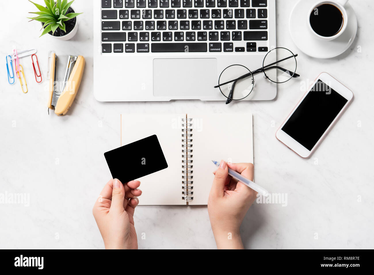 Una donna sta facendo un acquisto online, mock up e della carta di credito cellulare mobile sulla scrivania in ufficio isolato in modo bello sfondo marmo, copia spac Foto Stock