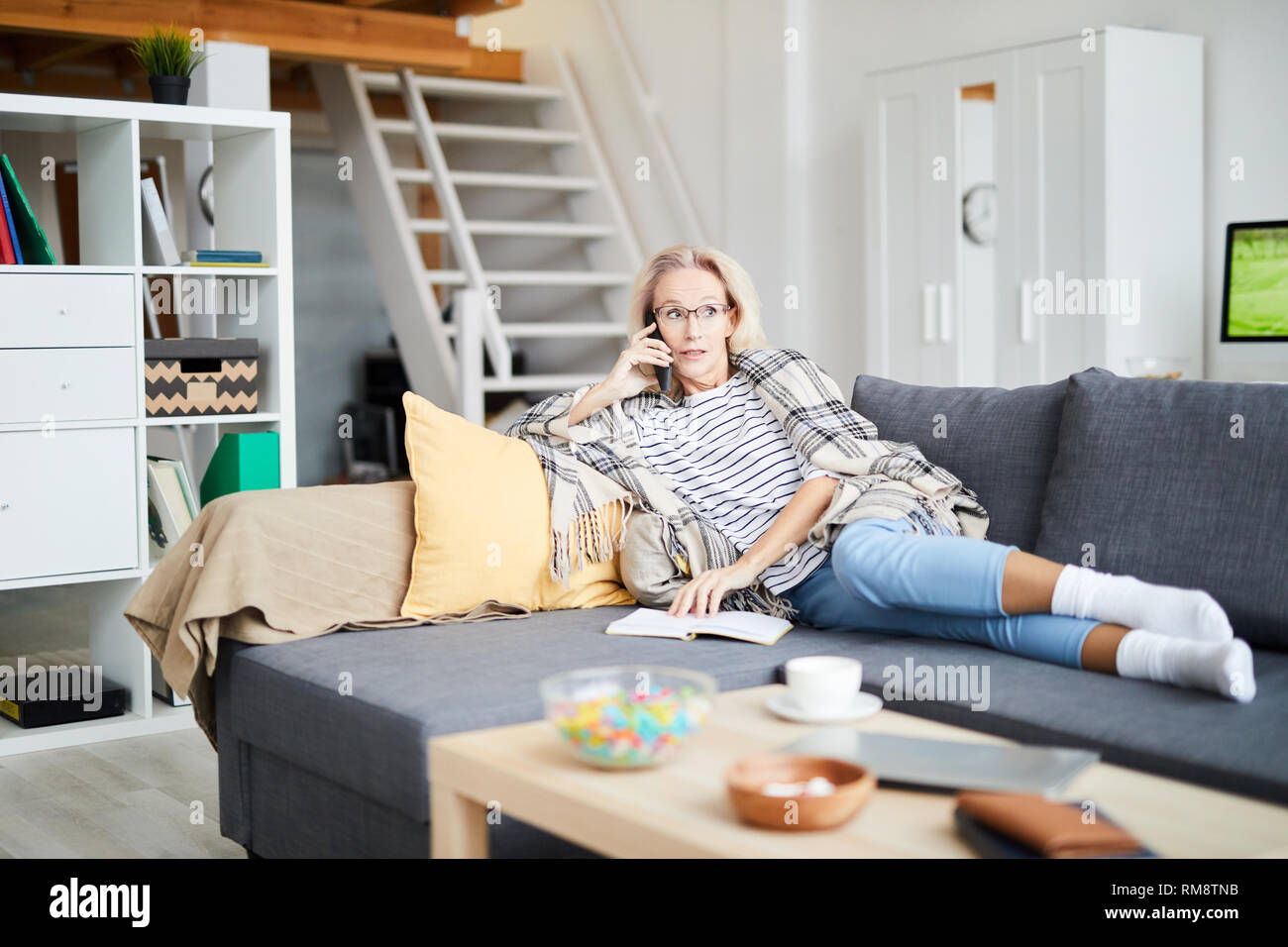 Donna che parla al telefono di casa Foto Stock