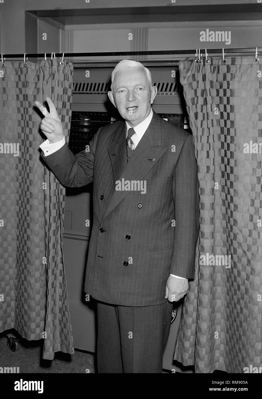 Il sindaco di Chicago Martin Kennelly lampeggia un segno di vittoria mentre emergente dalla cabina dopo la votazione democratica in primario nel febbraio 1955. Egli ha perso la gara per upstart Richard J. Daley. Foto Stock