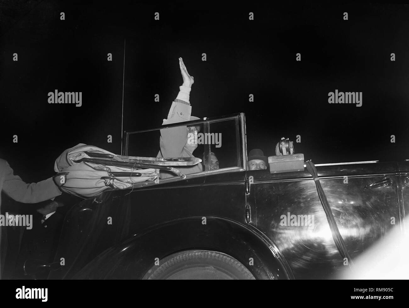 Il presidente Franklin Roosevelt onde dal sedile posteriore di una limousine, ca. 1944. Foto Stock