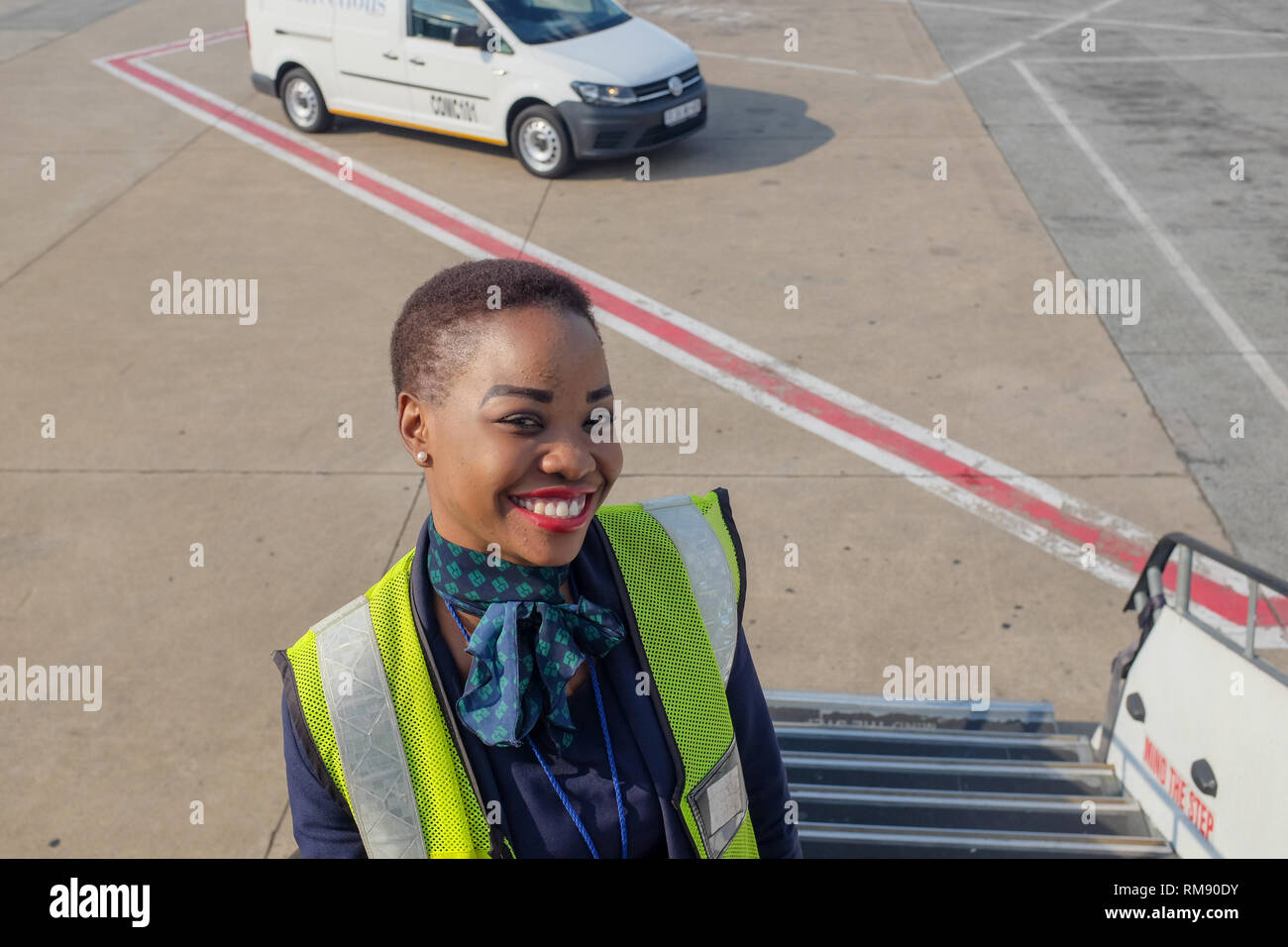 Un dipendente della compagnia aerea si erge sulla scalinata che conduce ad un volo British Airways da Johannesburg a Cape Town dopo i passeggeri sono imbarcati. Foto Stock