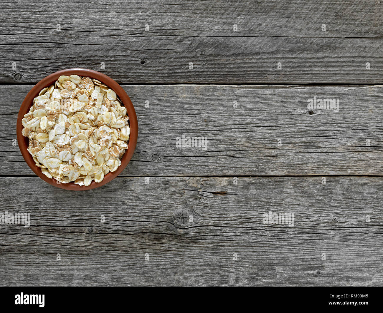 Di fiocchi di cereali in marrone della piastra sulla tabella di schede di grigio. Foto Stock