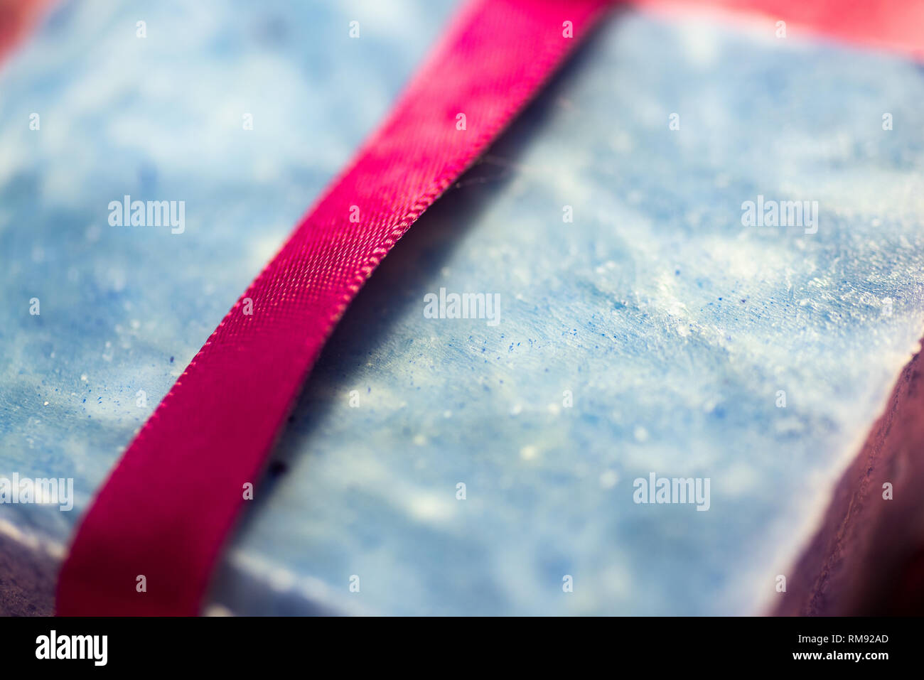 Bar di blu artigianale il sapone con un nastro rosso. Foto Stock