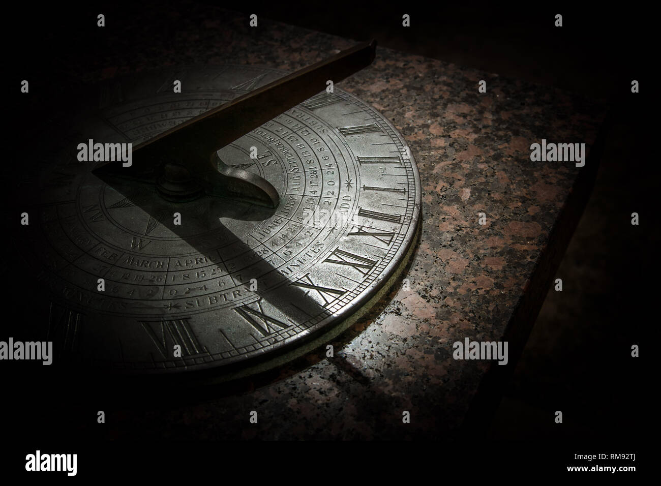 Il sole proietta un'ombra su un antico orologio solare Foto Stock