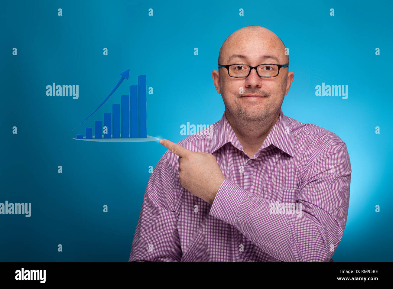 Un imprenditore in un spinaroli shirt puntando con il dito indice e una infografica, su sfondo blu. Foto Stock