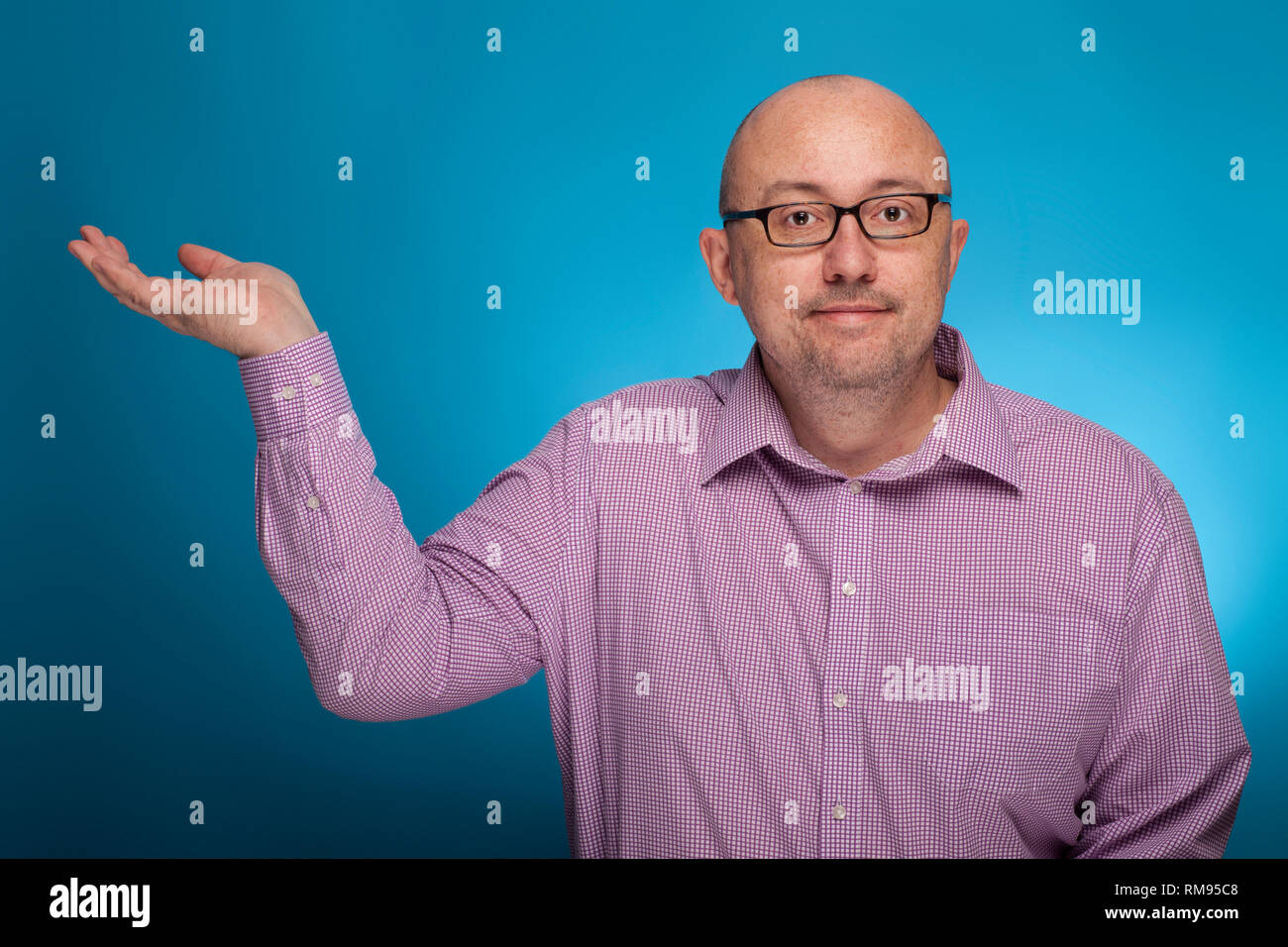 Un imprenditore in un spinaroli shirt nell'azienda pongono, su sfondo blu. Foto Stock