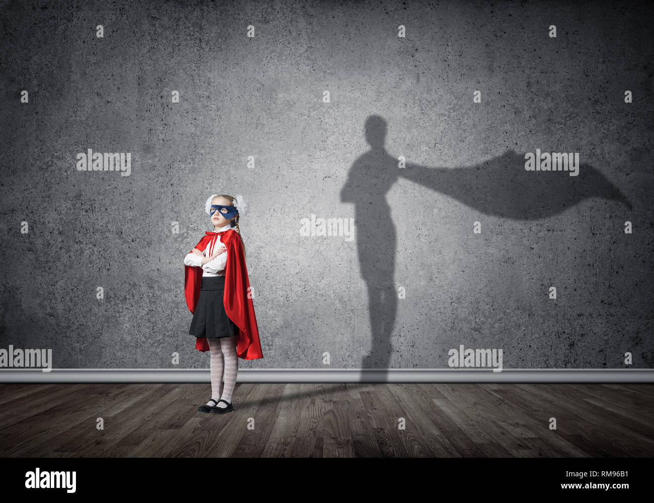 Girl power concetto con cute kid custode e ombra sul muro. I supporti misti Foto Stock