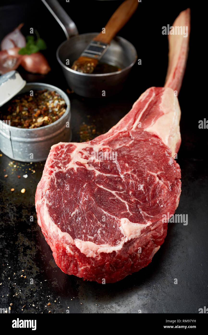 Pezzo di materie costola occhio tomahawk bistecca in vista ravvicinata sul bancone scuro Foto Stock