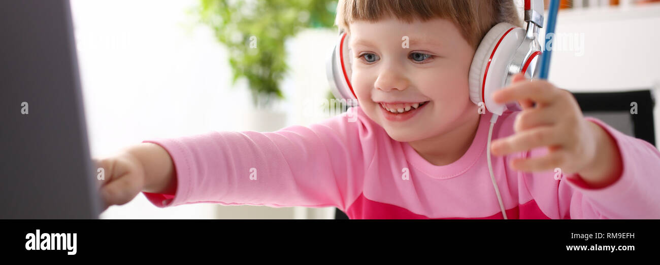 Bambino soddisfatto nella seduta delle cuffie Foto Stock