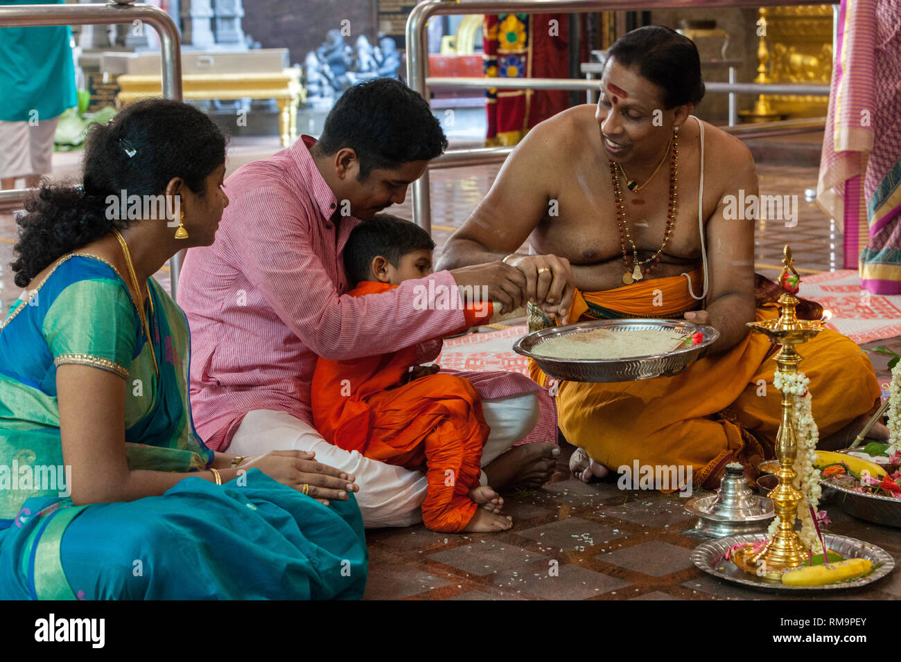 Sacerdote indù la benedizione di un giovane ragazzo, Sri Senpaga Vinayagar Ganesh Hindu Temple, Joo Chiat distretto, Singapore. Foto Stock