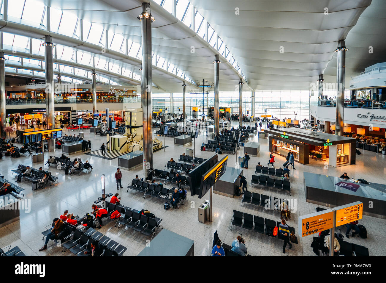 Londra, Inghilterra, Feb 13, 2019: alta vista prospettica dei passeggeri e negozi al terminal di partenza a Heathrow Terminal 3 Foto Stock