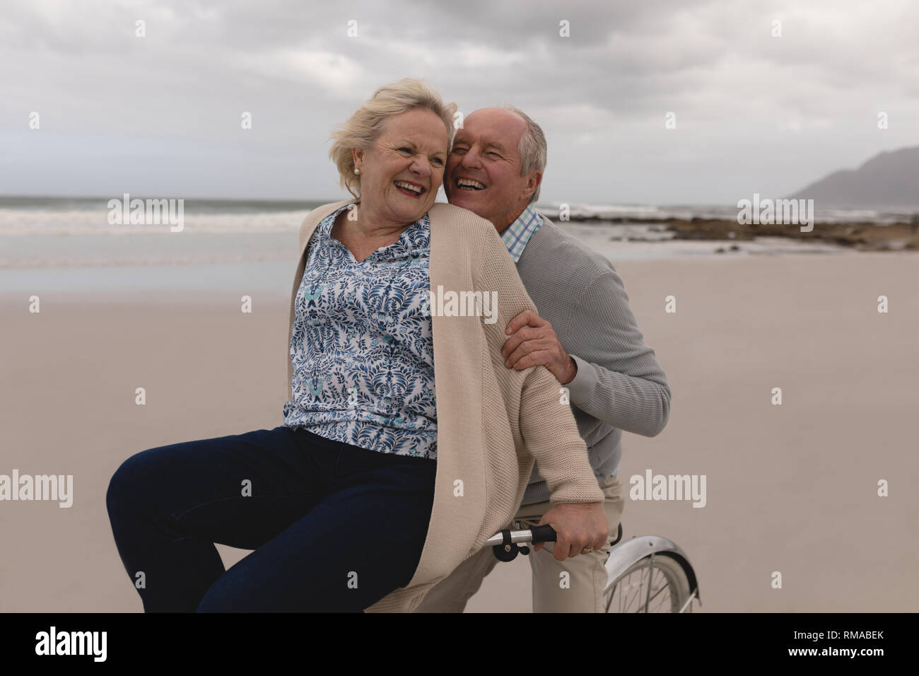 Senior con uomo donna senior Bicicletta Equitazione sulla spiaggia Foto Stock