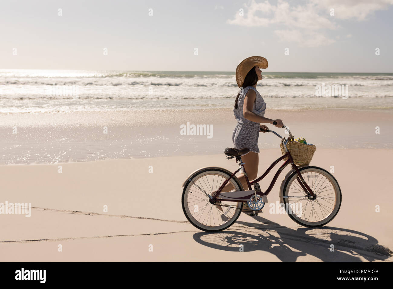 Bella giovane donna con la bicicletta passeggiate sulla spiaggia Foto Stock
