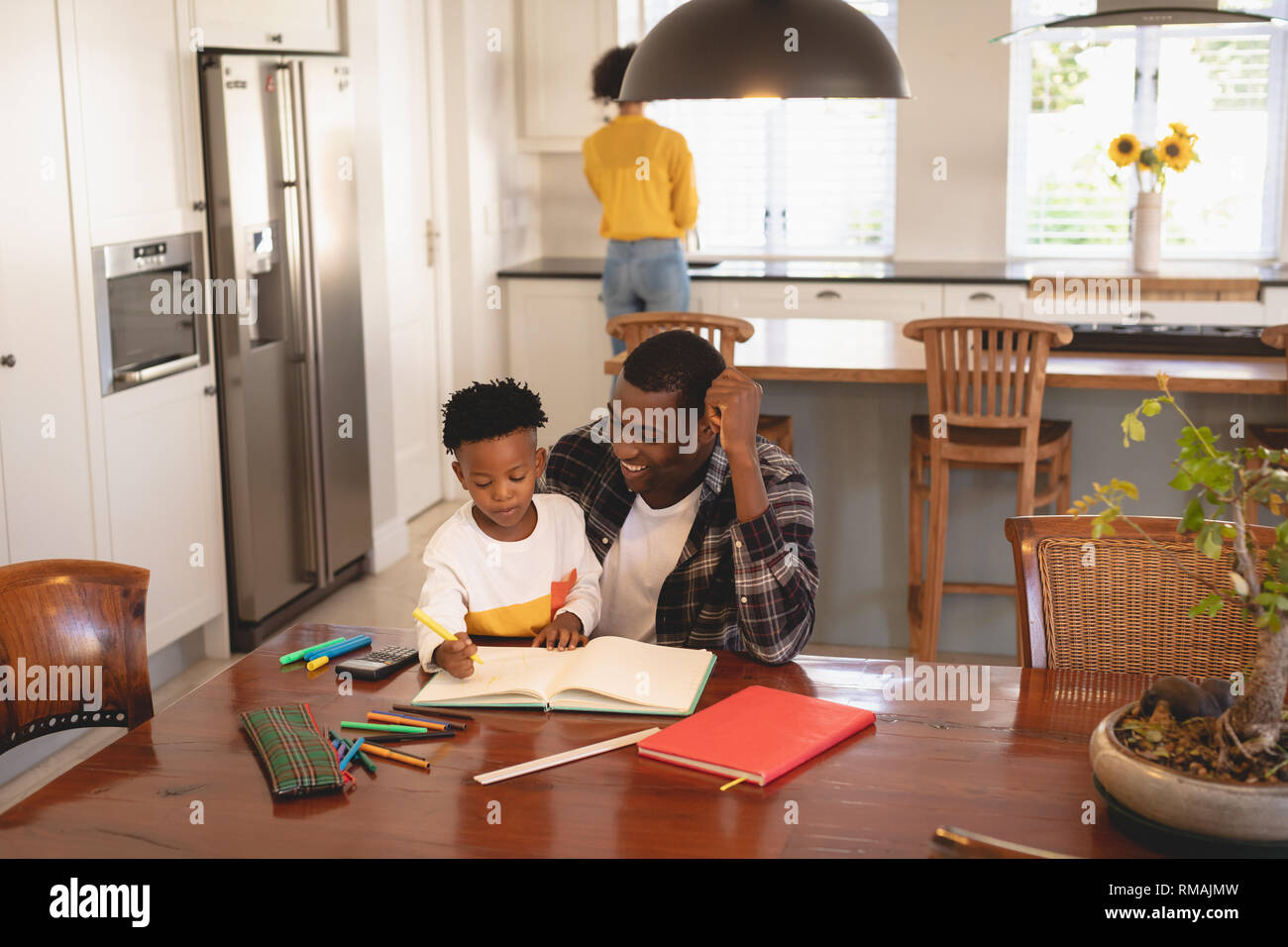 African American padre aiutando il suo figlio con i compiti a tavola Foto Stock