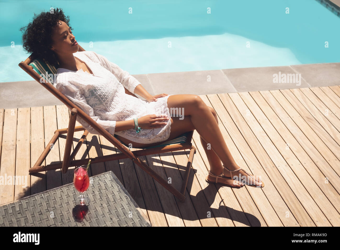 African American donna relax sulle sdraio nel suo cortile Foto Stock