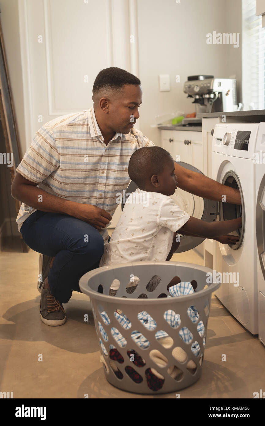 African American padre e figlio il bucato in lavatrice Foto Stock