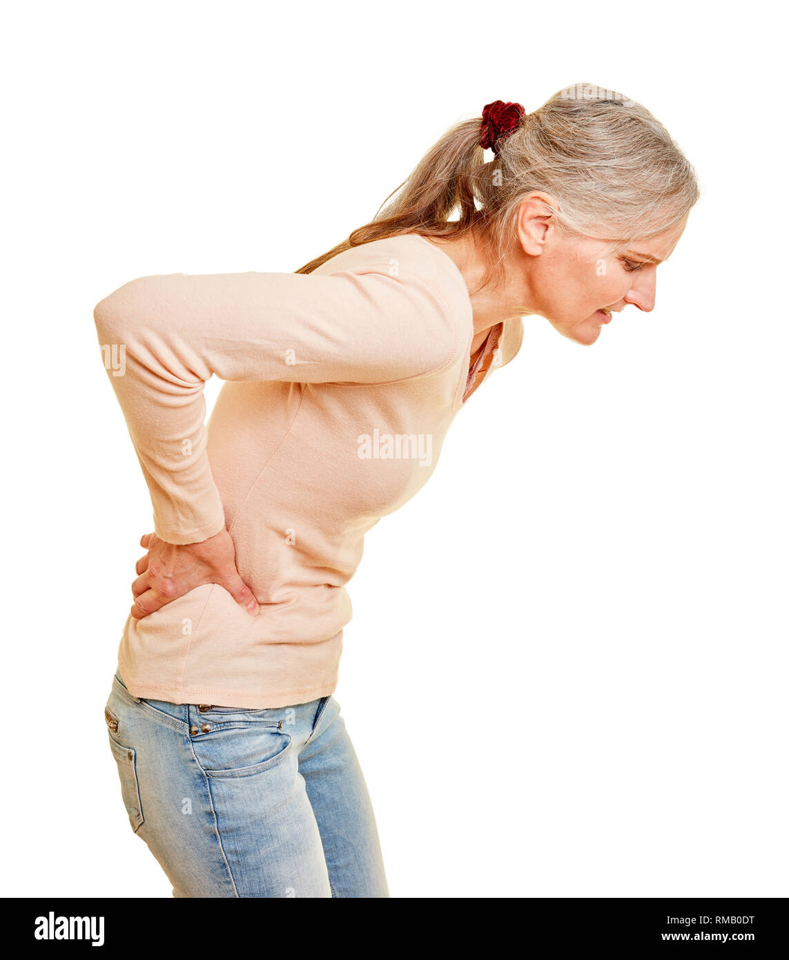 Donna anziana con dolore alla schiena si inclina in avanti Foto Stock