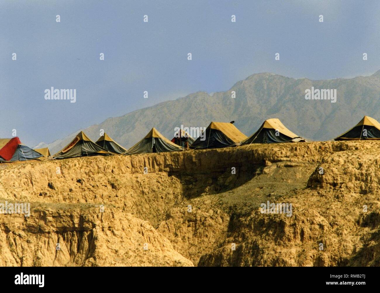 Campo di rifugiati da tempo dell'occupazione sovietica dell'Afghanistan. Migliaia di profughi vivono su una pianura brulla sul confine afghano. Foto Stock