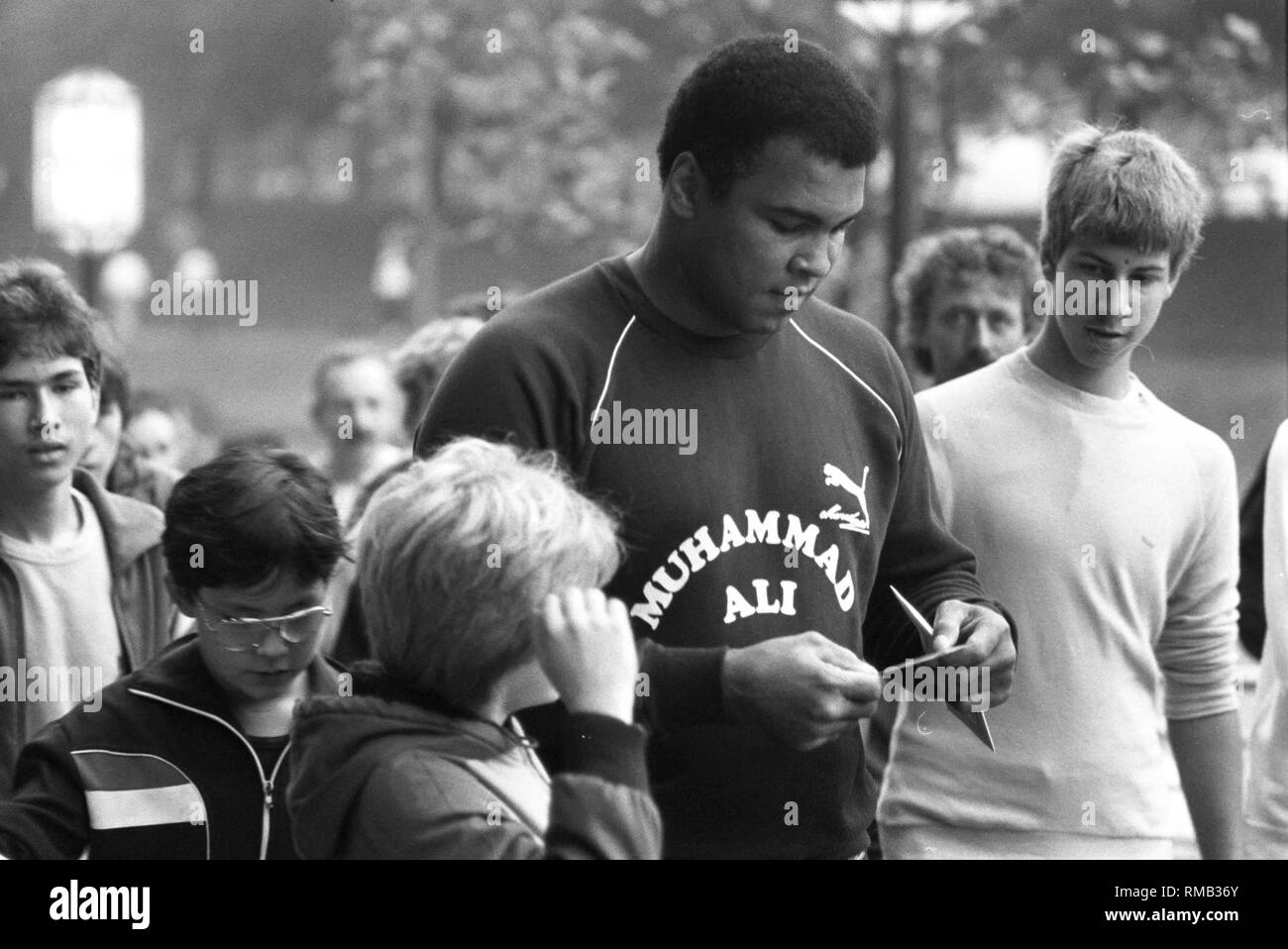 L'ex American boxing campione del mondo e campione olimpico Muhammad Ali dà il suo giovane fan autografi. Foto Stock