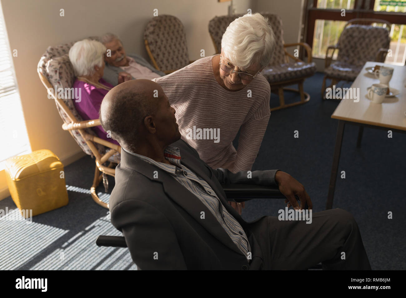 Senior Donna che parla con disabilita uomo senior presso la casa di cura Foto Stock