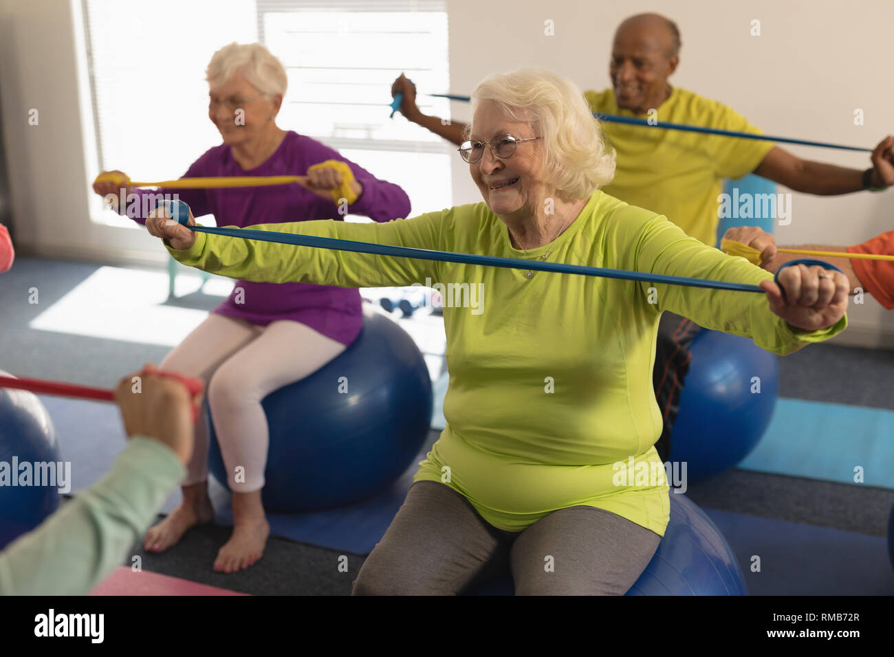 Senior persone che esercitano con banda di resistenza in studio fitness Foto Stock