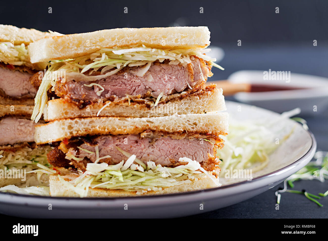 Sando Katsu - cibo giapponese di tendenza in sandwich con carne di maiale impanato chop, cavolo e il tonkatsu salsa. La cucina giapponese. Foto Stock