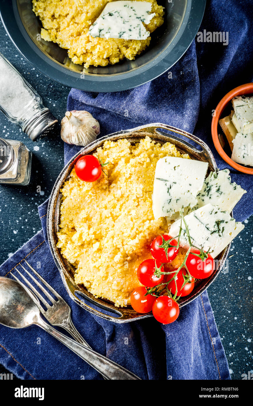 Lombardia il cibo italiano, la polenta di mais con farinata di pomodori con formaggio gorgonzola, blu scuro dello sfondo spazio di copia Foto Stock