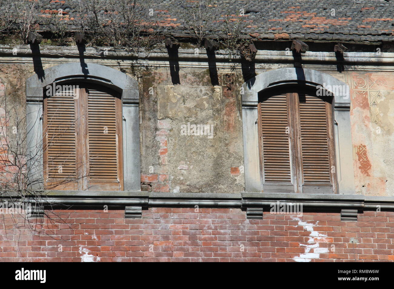La vecchia casa in mattoni rossi con otturatore chiuso. Esempio antica casa nel nord Italia. Foto Stock