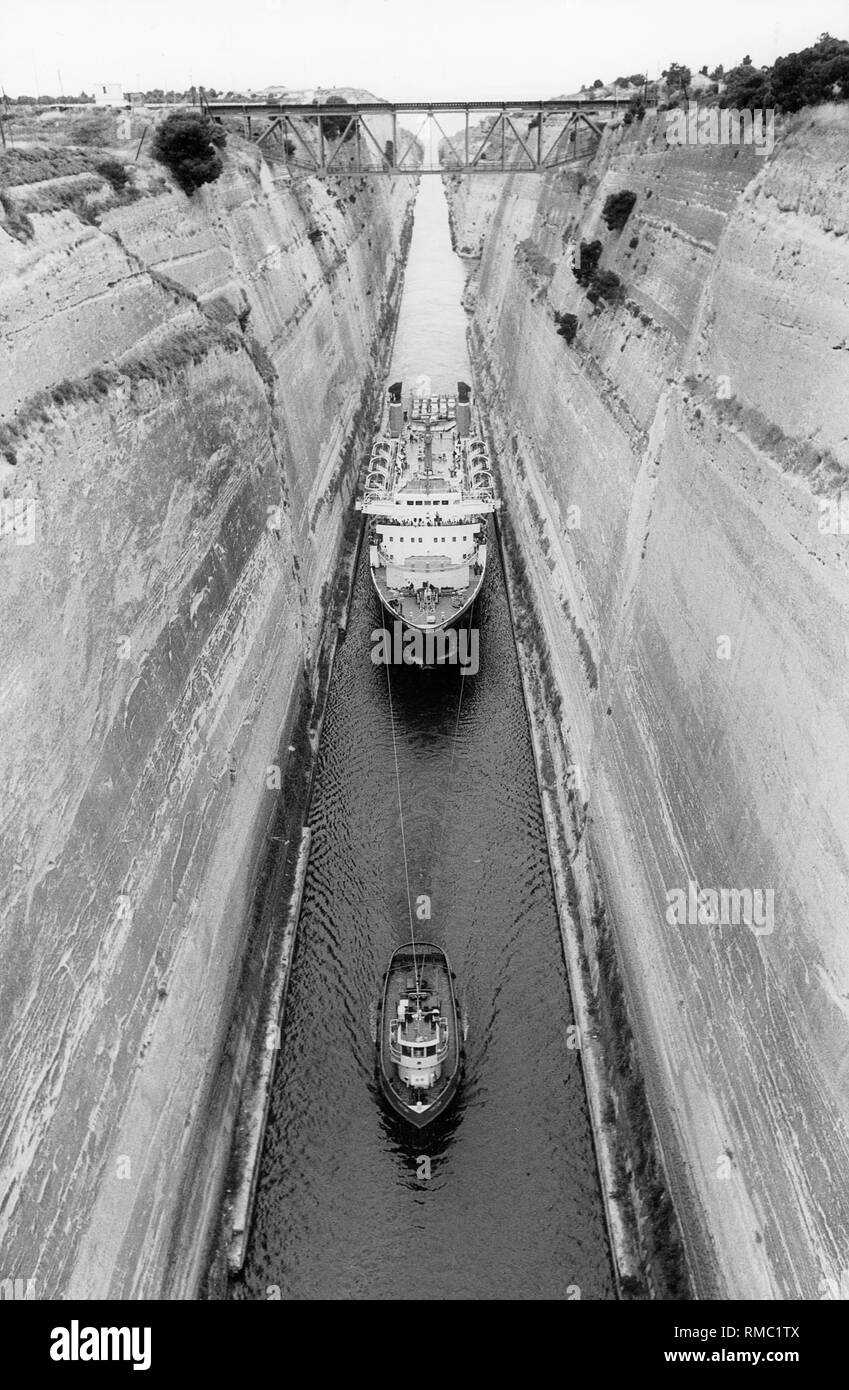 Il Canale di Corinto con un ponte ferroviario. Si tratta di 6,5 km di lunghezza ed è stato inaugurato nel 1893. Esso collega la penisola del Peleponnes con la terraferma. Qui, una nave passeggeri è tirato da un pilota attraverso il canale nel 1984. Foto Stock